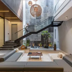 Inside the Casa Acentuada project, I designed this sunken lounge to be a tranquil heart of the home. The double-height space is anchored by a natural stone wall and a floating staircase, creating a dramatic interplay of light, volume, and texture.