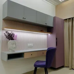 A stylish study or work-from-home corner. The combination of grey and lilac cabinets with a light wood desk creates a modern and inspiring workspace.