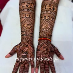 A beautiful example of bride and groom portraits on the palms. The rest of the design is filled with traditional motifs like elephants and paisleys, making the portraits stand out.