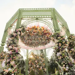 A closer look at the top of the gazebo mandap, where a floating floral chandelier and soft pink draping add a touch of softness against the sky.