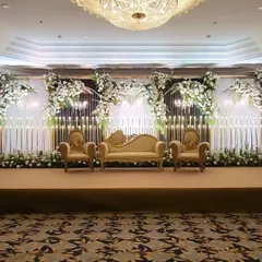 This stage design embodies pure elegance for a classic reception. We combined grand Victorian-style seating with a modern backdrop of cascading white florals and hundreds of warm, glowing candles to create a truly romantic focal point.