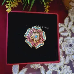The 'Anokhi' adjustable ring. This large, floral-shaped cocktail ring features vibrant pink and blue stones, making it a true statement piece.