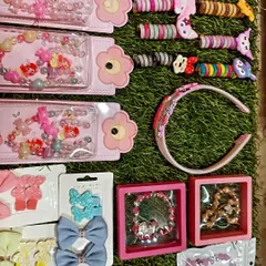 This image shows a collection of my cute hair accessories for kids. It includes beaded character bracelets, hair ties, sparkly bow clips, and headbands.
