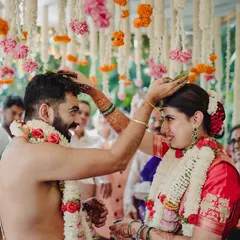 A close-up of a key moment in a South Indian wedding ceremony. The couple's smiles show their happiness and connection as they participate in the traditional rituals.