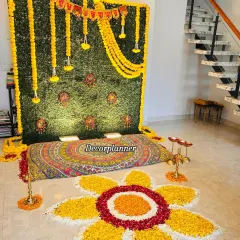 This angle shows how the entire Annaprashan setup comes together in a home living space. The vibrant colors of the rangoli and backdrop stand out, creating a festive focal point for the celebration.