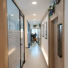 This is a view down the corridor of our new Vasundhara clinic, leading to our private treatment rooms like 'Jasmine'. The space is designed to be serene and clean, ensuring a peaceful and professional environment for all your aesthetic and wellness treatments.