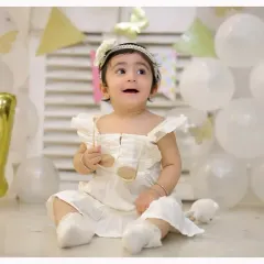 An elegant and simple first birthday theme with white balloons and delicate butterflies. This setup creates a dreamy and timeless portrait of your little one.