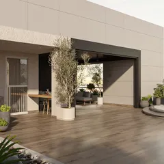 The terrace was designed as a multi-level urban oasis. This wide view shows the seamless flow from the semi-enclosed lounge to the open-air deck, with carefully placed planters and an olive tree creating a lush, green environment high above the city.