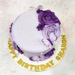 We create a dreamy vision with this lavender butterfly cake. A cascade of purple buttercream roses and delicate, edible butterflies adorns the textured lavender frosting, accented with tiny pearls for a touch of magic and elegance.