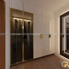 This modern floor-to-ceiling wardrobe features a striking combination of glossy white laminate and black tinted glass with a gold-finish aluminum frame. The design includes a display section with internal lighting for showcasing prized items.