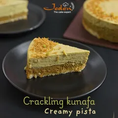 A slice of our Crackling Kunafa and Creamy Pista cake. This dessert offers a perfect fusion of textures, with a crunchy kunafa base and a smooth, rich pistachio cream layer on top.
