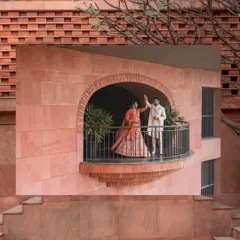 A creative, wide-angle shot capturing the couple sharing a dance on a balcony. Framing them within the building's architecture adds a unique perspective and a sense of scale to this romantic pre-wedding moment.