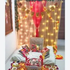 I create special, cozy setups for a baby's Annaprashan or first rice-eating ceremony. This design includes a soft, low seating area under a net canopy with twinkling lights, a 'Shubh Annaprashan' banner, and a traditional floral rangoli with spaces for all the ceremonial bowls.