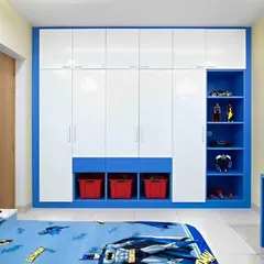 A large, built-in wardrobe for a child's room in a blue and white theme. It includes open shelving for toys and display items, along with lower cubbies for easy-to-reach storage bins.