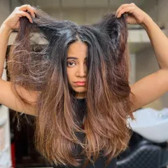 This is the "before" shot of hair that's become frizzy and lost its shape. It's the perfect canvas for a smoothing treatment and color correction to bring it back to life.