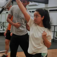 A coach provides a cue during a landmine press. We emphasize mindful movement, ensuring you engage the right muscles and maintain proper form throughout every exercise.
