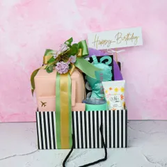 The ultimate birthday hamper, packed with personalized travel essentials and pampering treats. This gift set, presented in a stylish striped bag, is sure to make their day brighter.