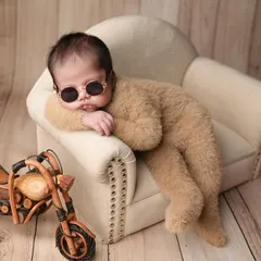 Our little man has all the swag. This "cool rider" setup with a miniature motorcycle and sunglasses shows that even the tiniest babies can have a big personality.