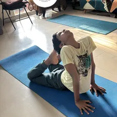 A young boy practices Eka Pada Rajakapotasana (One-Legged King Pigeon Pose), demonstrating impressive flexibility and focus. Yoga is a fantastic tool for developing body awareness in children.