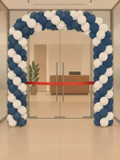 An illustration of a navy and white balloon arch framing the glass double door of an office, with a red ribbon across the doorway and a reception desk behind the glass