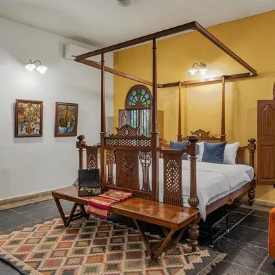 The Arundati bridal suite, featuring a magnificent four-poster bed, antique furniture, and walls adorned with classic Indian art.