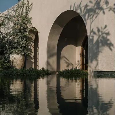The interplay of light and shadow on the lime-plastered arches of the Dua Villa. The building’s form creates deep shadows, while the water reflects the sky, resulting in a composition that feels both monumental and weightless.