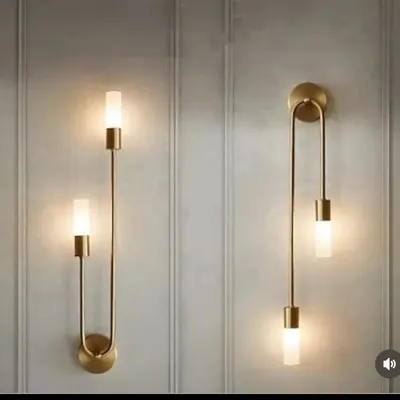 A pair of modern U-shaped wall sconces in a brass finish. These elegant fixtures provide both up and down lighting, adding a sophisticated touch to any wall.