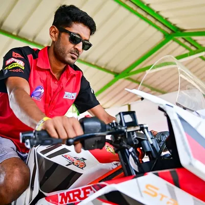 A coach on a race bike in the pits. The work behind the scenes is just as important as the action on the track.