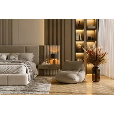 A luxurious bedroom featuring a floor-to-ceiling upholstered and wood-paneled headboard. The integrated bedside lighting and built-in bookshelf create a cozy and functional reading nook.