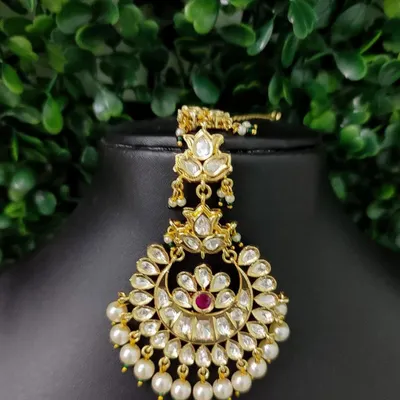 A classic and elegant kundan maang tikka with a crescent design, surrounded by pearls. This is one of my most popular rental pieces.