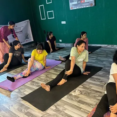 An instructor guides a student during a yoga workshop. The studio provides a focused environment for teaching and one on one attention.