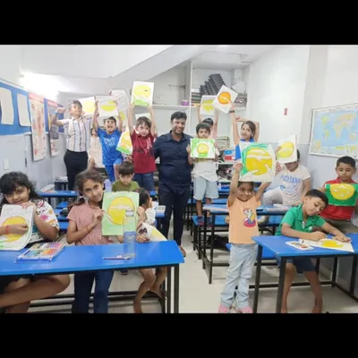 The joy of creation. Our students proudly hold up their finished paintings for the camera, their faces beaming with a sense of accomplishment after a productive art session.