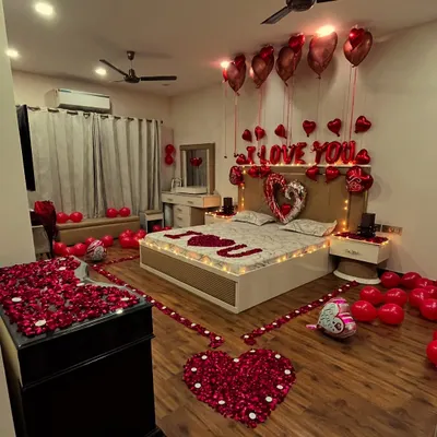 This is the full view of one of our most requested romantic room transformations. We use a combination of floor balloons, helium balloons, rose petal arrangements on the floor and bed, and custom foil letters to create a complete surprise experience.