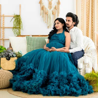 A serene moment between an expecting couple in our boho-themed studio. The beautiful teal gown is one of many options available from our client wardrobe for your maternity session.