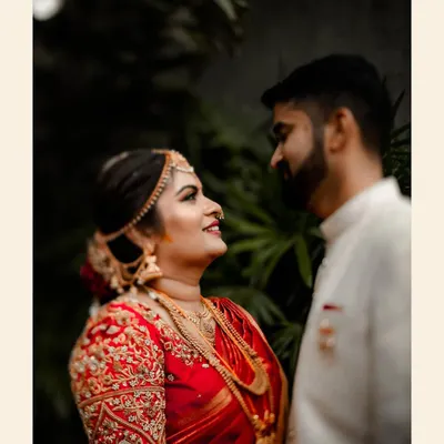 A quiet moment of connection between the bride and groom. The intricate embroidery on her blouse and the soft look they share make this a timeless South Indian wedding portrait.