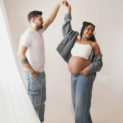 A fun, spontaneous dance in the studio. This casual denim look is perfect for couples who want their maternity photos to reflect their modern, playful style.
