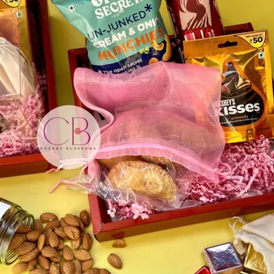These Roka return favours are a perfect blend of traditional and modern tastes. Each red tray was filled with a jar of almonds, handmade Gujjia, and a mix of branded and homemade chocolates.