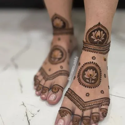 This Pinterest-worthy feet design is a modern favorite. It features a prominent lotus mandala on the top of the foot with delicate surrounding details for a very chic look.