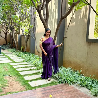 A full shot of my plain purple saree paired with a vibrant, multi-color printed blouse. I love pairing simple sarees with contrast printed blouses. This look, set in a beautiful garden, feels so serene.