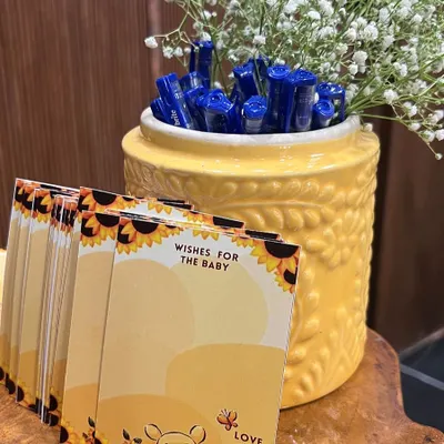 Sweet details for a "Baby in Bloom" shower, including Winnie the Pooh themed "Wishes for the Baby" cards and pens for guests.