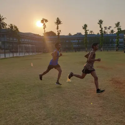 Two athletes executing a running drill against a sunset backdrop, embodying our philosophy to "run like no one's watching."