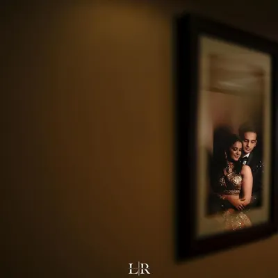 A creative couple portrait captured as a reflection in a framed picture. We love using unconventional angles and compositions to create artistic and memorable shots.