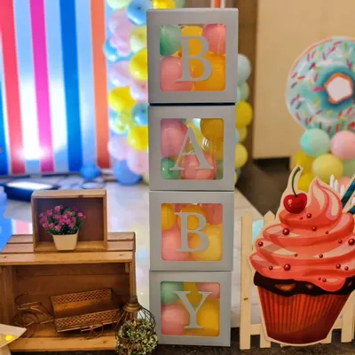 I love creating fun themes like this candyland party. These 'BABY' blocks filled with colorful balls, along with cupcake and donut cutouts, add a playful and sweet touch to the decor.