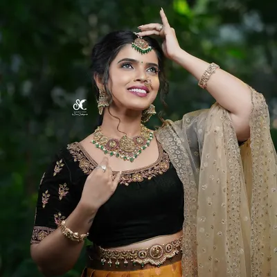 A beautiful portrait for a makeup artist's portfolio. The model's joyful expression and the rich details of her traditional attire are captured in soft, natural light.