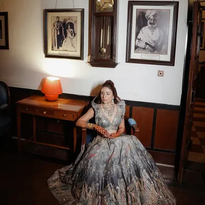 This is a classic, elegant bridal portrait. We teach you how to use a single light source to sculpt the subject, creating soft shadows that highlight her features and the texture of her lehenga. The composition is centered and formal, fitting the royal venue.
