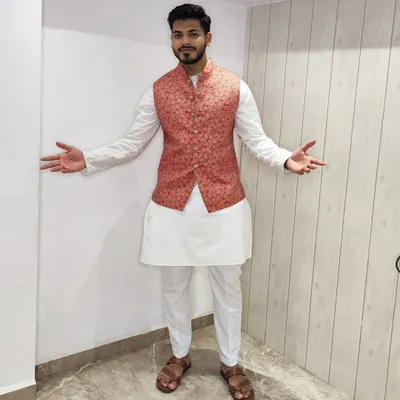 A classic white kurta-pajama set styled with a vibrant floral Bandi jacket. The white base is versatile, allowing you to pair it with jackets of any color for different functions.