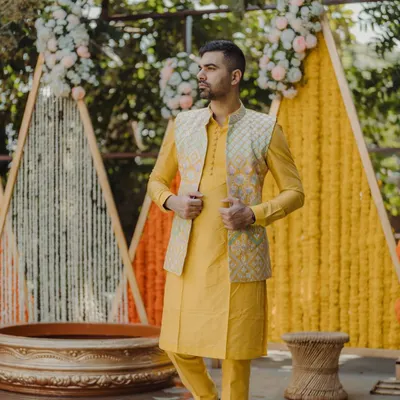 A stylish portrait of the groom during his Haldi ceremony. The vibrant yellow kurta perfectly complements the marigold decor, and my photography captures his confident and happy demeanor.