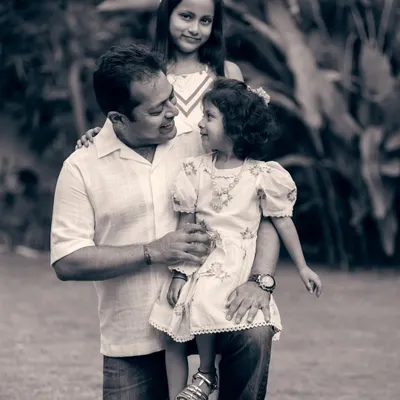 A father's loving gaze at his daughter. This black and white family portrait emphasizes the emotional connection and timeless nature of their bond.