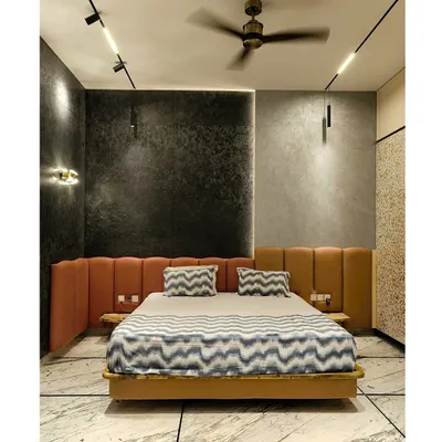The master bedroom in our "House Reversed" project features an exotic, shimmering matrix stone wall, complemented by a warm leather headboard and dramatic lighting.
