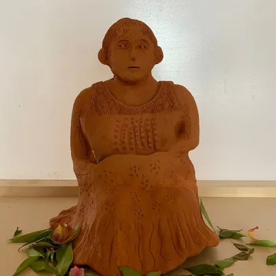 In the gentle rhythm of clay, we find solace. This terracotta sculpture captures a quiet, soulful moment.
